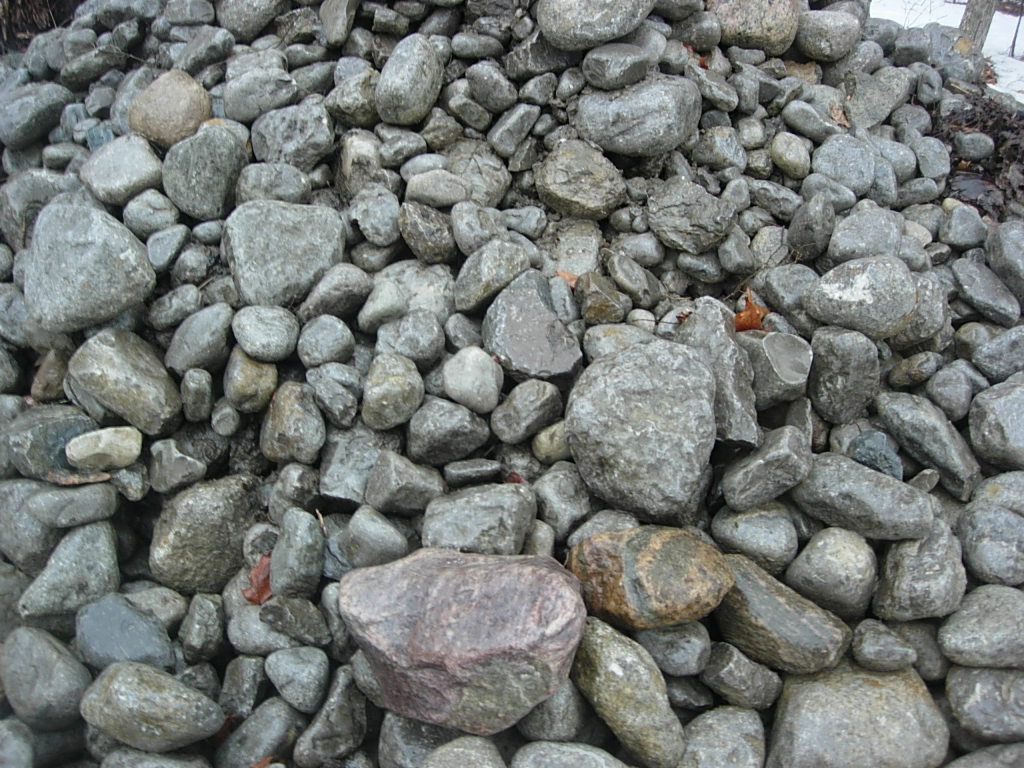 large rocks piled on top of each other next to bushes