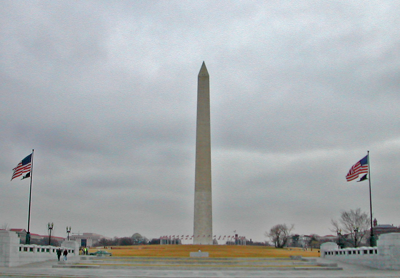 a view of the washington monument, with two flags waving