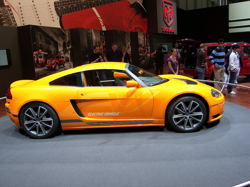 an orange sports car sitting on display at a convention