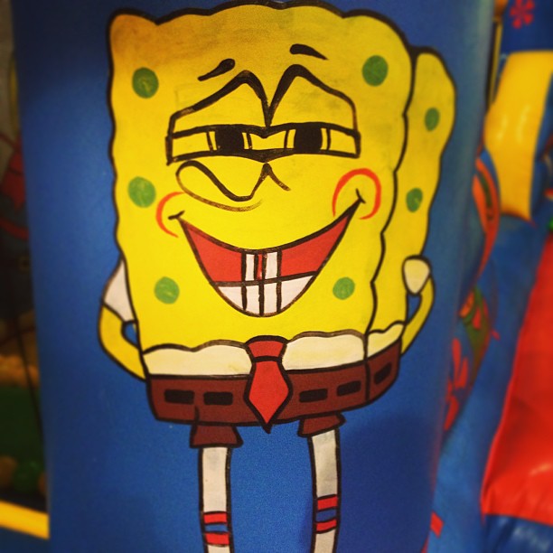 a cartoon spongebob is on a blue plastic bucket