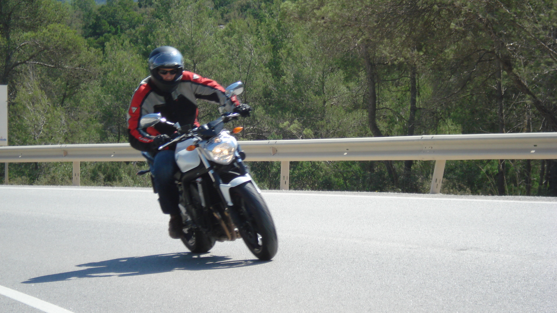 a man rides on his motor bike down the road