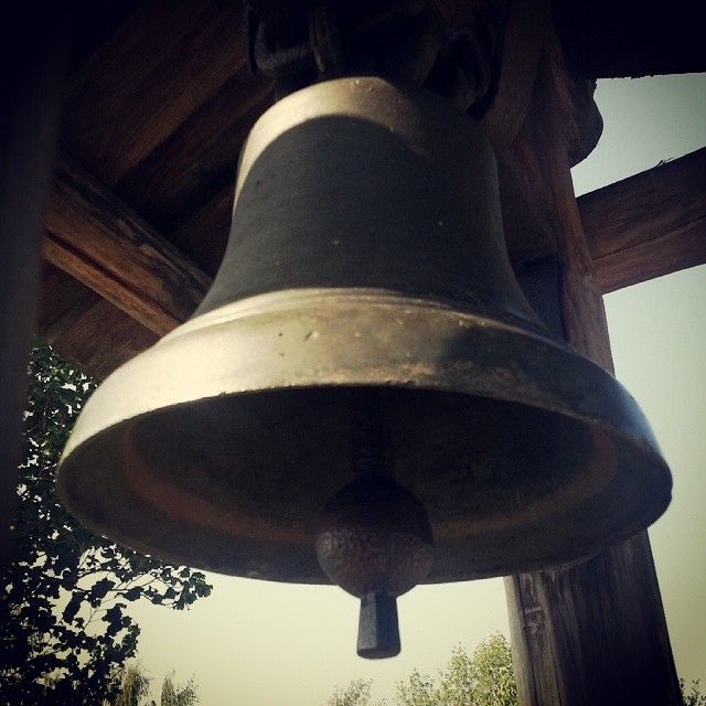 a bell is hanging from a wooden structure