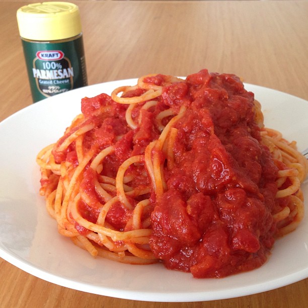 a plate of spaghetti topped with tomato sauce