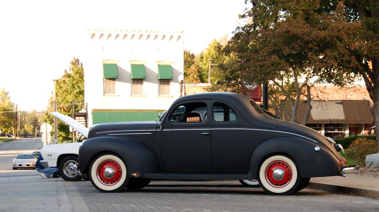 black car parked in front of a tree