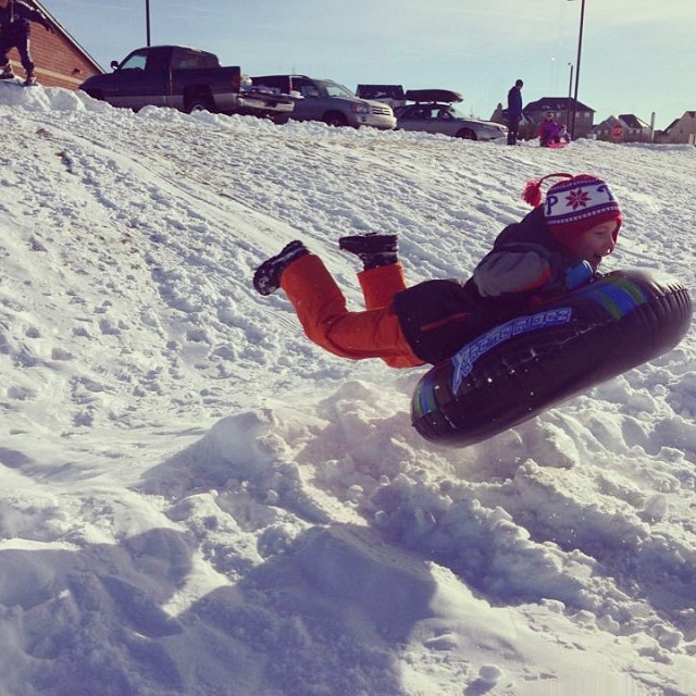 a small child is snowboarding down a hill