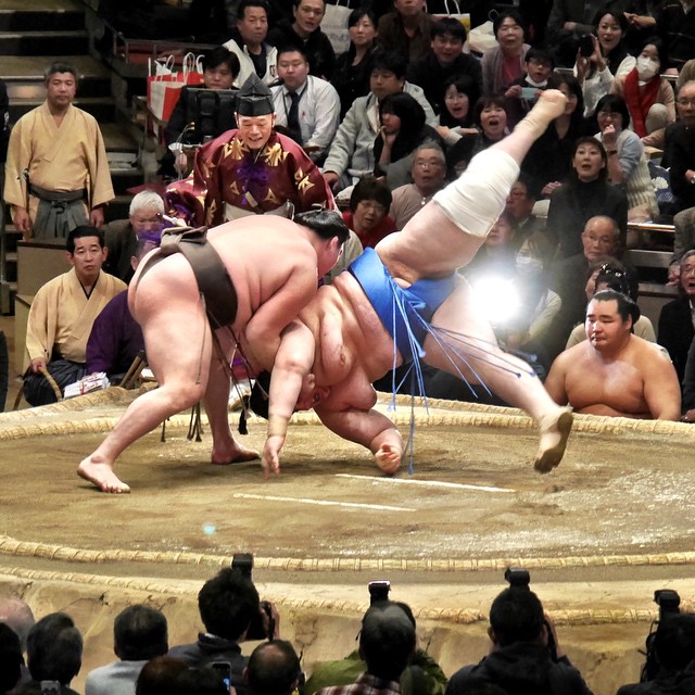 wrestlers are being caught in an arena by spectators