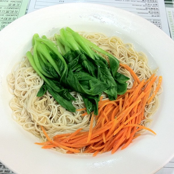 a plate of noodles and vegetables are sitting on a table