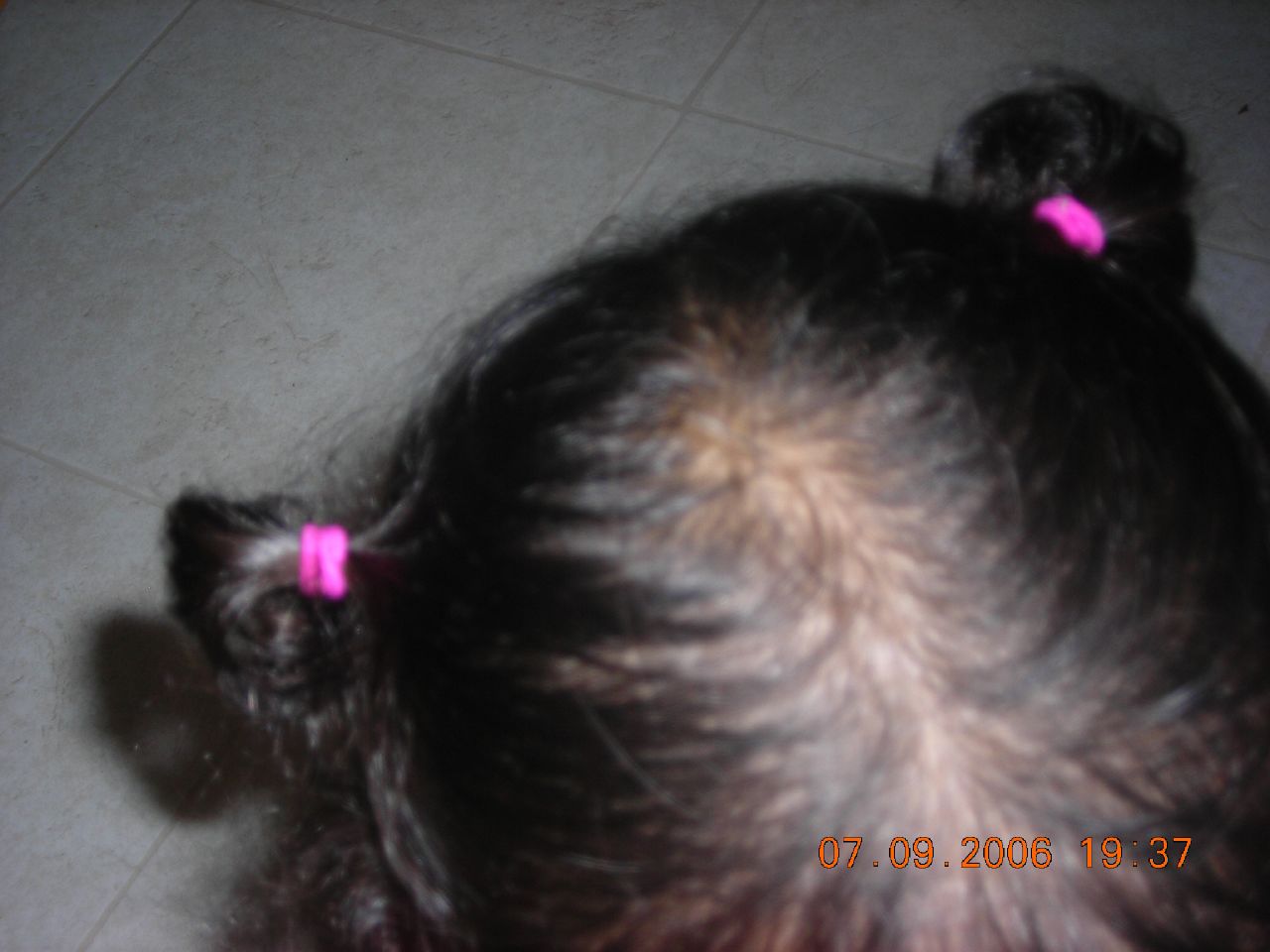 a person has two pink plastic bows on her hair