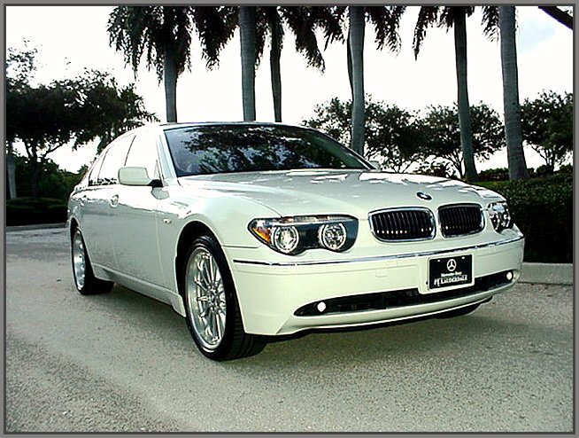 this is a white car parked in front of some palm trees