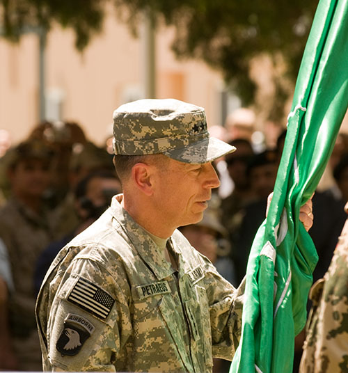 a man in uniform holding up the back end of a green flag