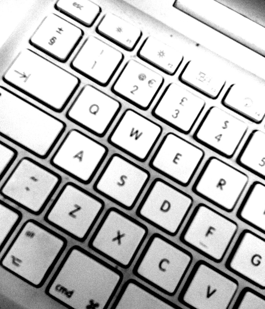 a computer keyboard sits on top of a desk