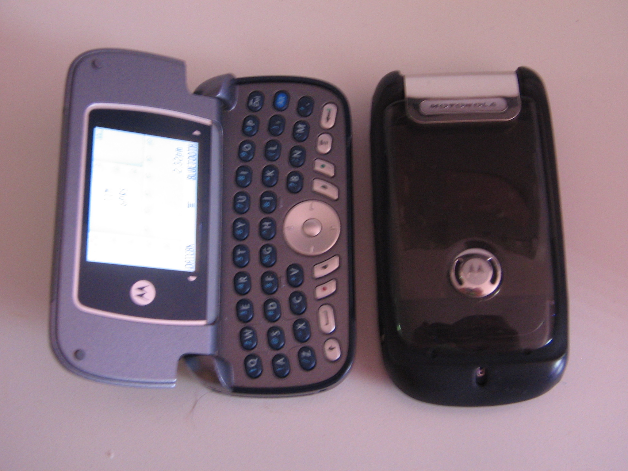 three cellphones are lined up on a table