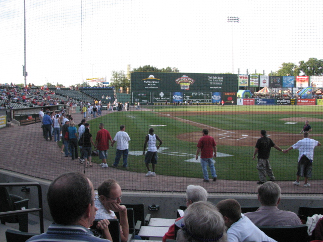 a group of people standing on a baseball field