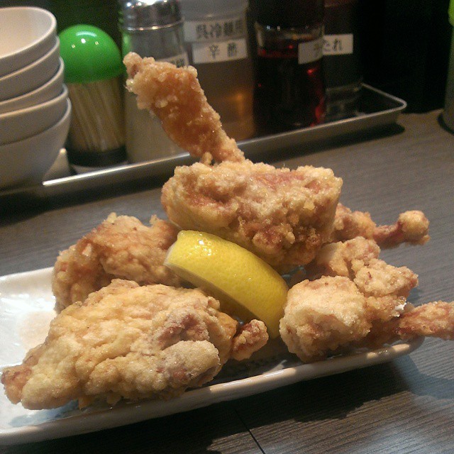 a small plate holding fried food next to white plates on a counter