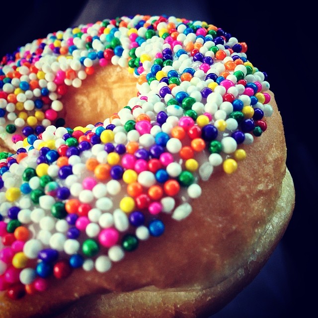 the donut has been made with multi - colored sprinkles