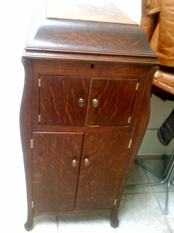 a small wooden dresser with two drawers and some leather chairs