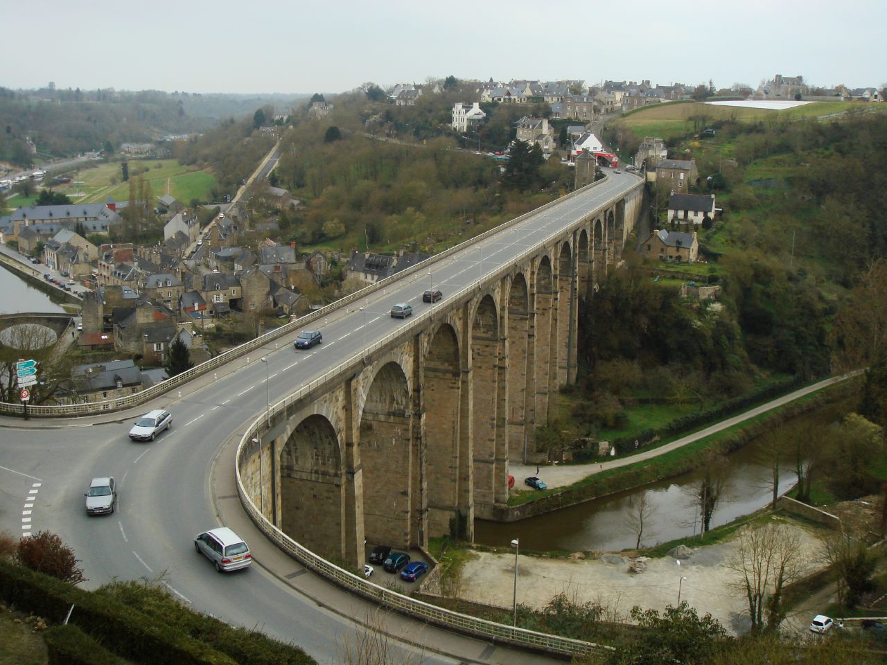 a bridge spanning over a highway, with cars driving on it
