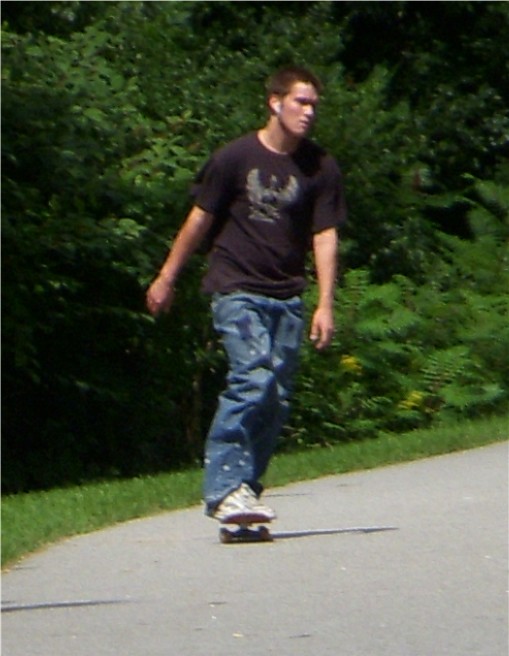 a man riding on the back of a skateboard down a street