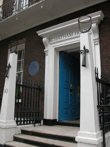 the entrance to chatham house, with wrought iron fence and blue door