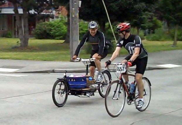 two men riding bikes on a city street