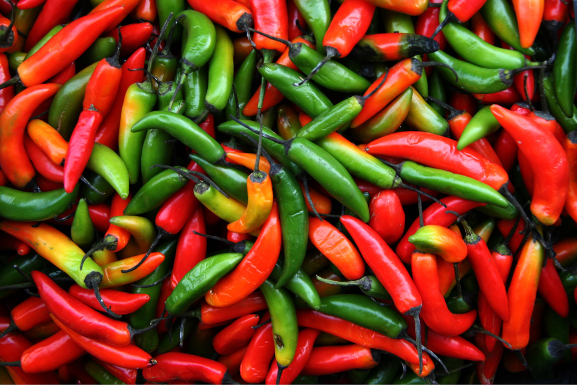 a closeup view of several capsacule peppers in a large bowl