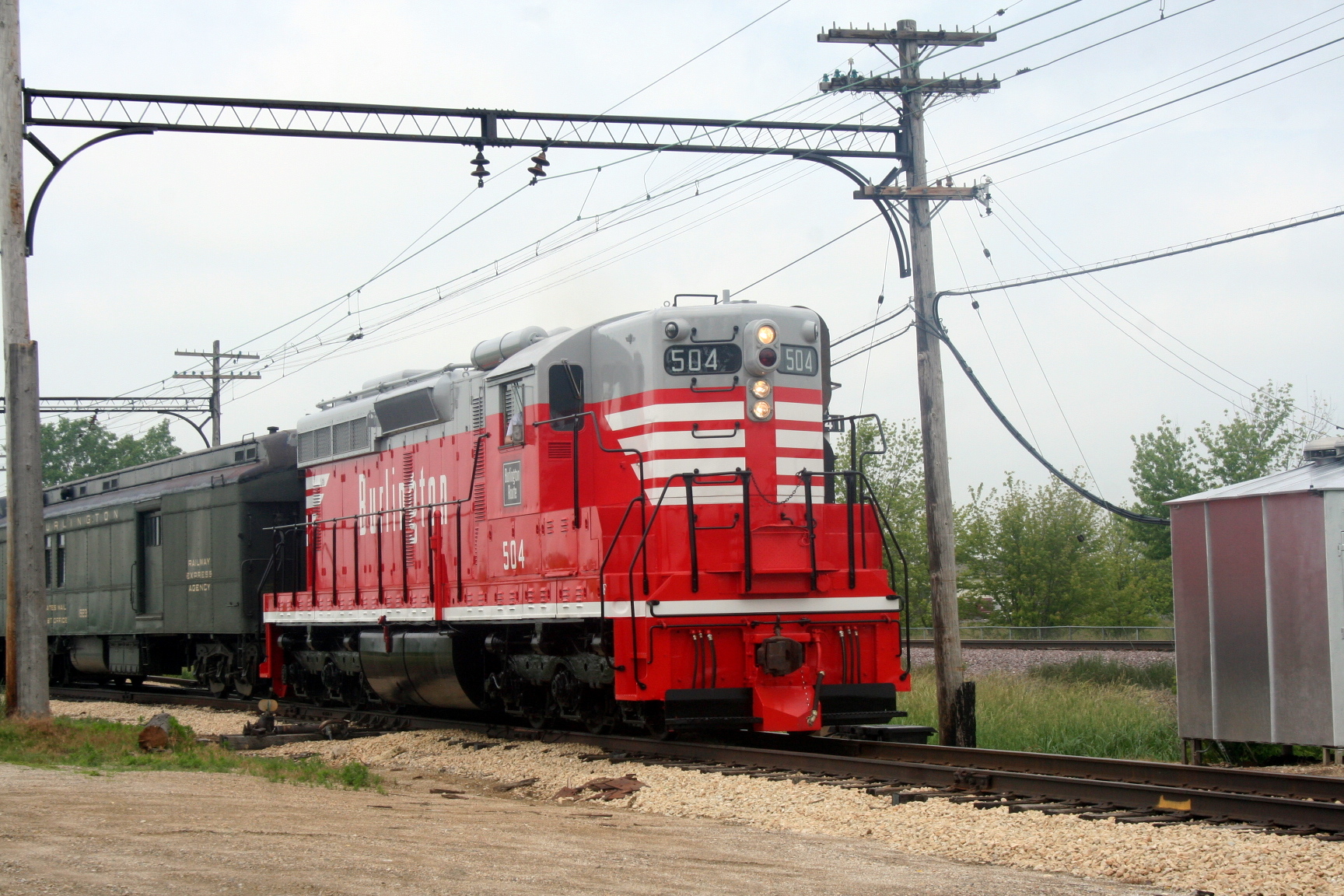 a red and gray passenger train on railroad tracks