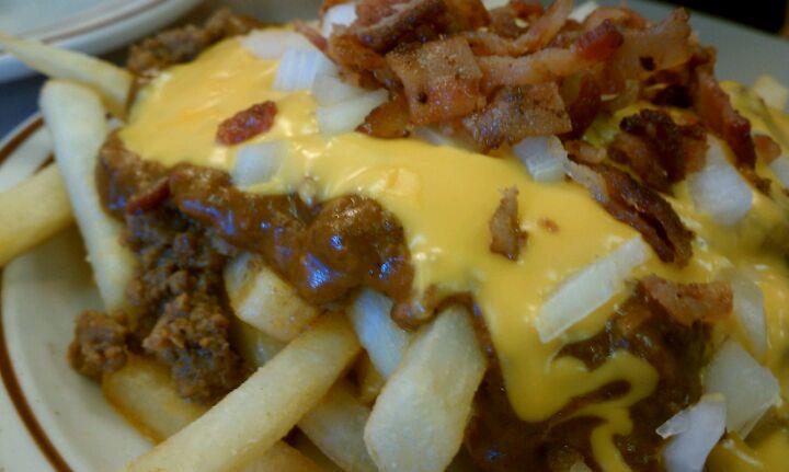 a plate full of french fries covered in cheese and meat