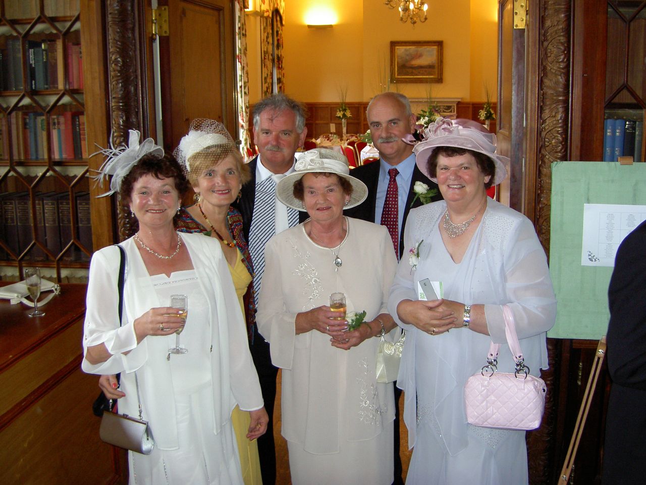 five people standing in a room and smiling