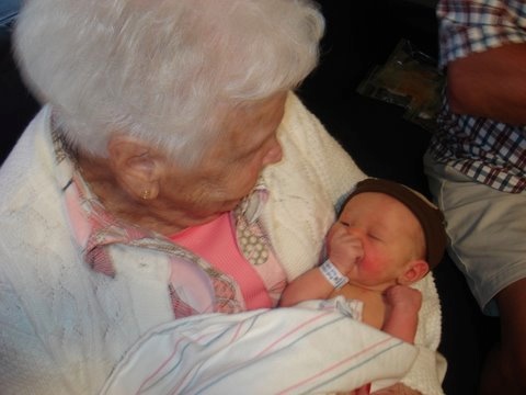 an older woman holding a small baby in her arms