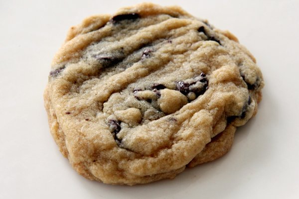 a chocolate chip cookie sitting on top of a white table