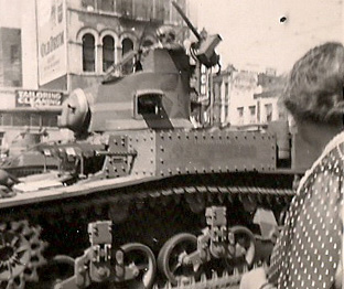 a man stands near a tank with an old camera