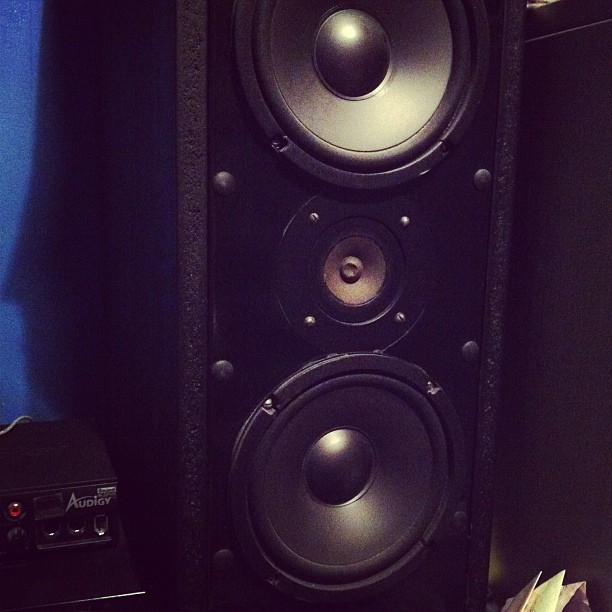 a large tower speaker next to some audio equipment