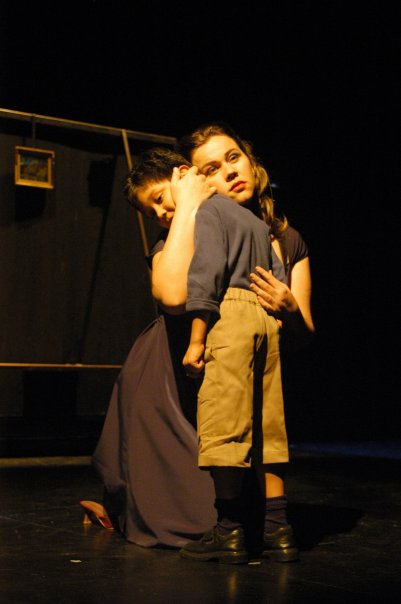two people hugging at the back of a stage
