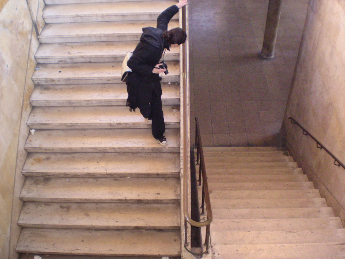 a woman climbs up the flight of stairs