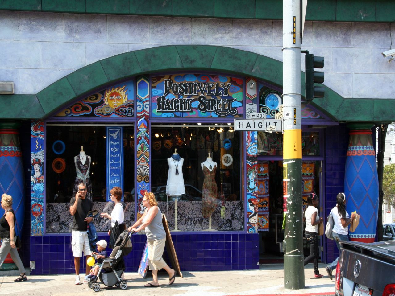 some people and strollers on the street outside of a fashion store