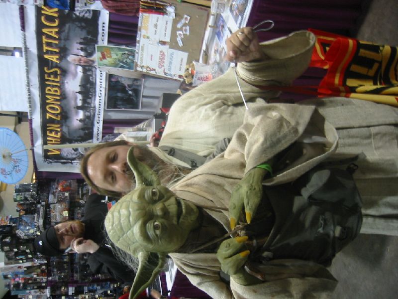 a man dressed in an yoda costume holds soing with both hands