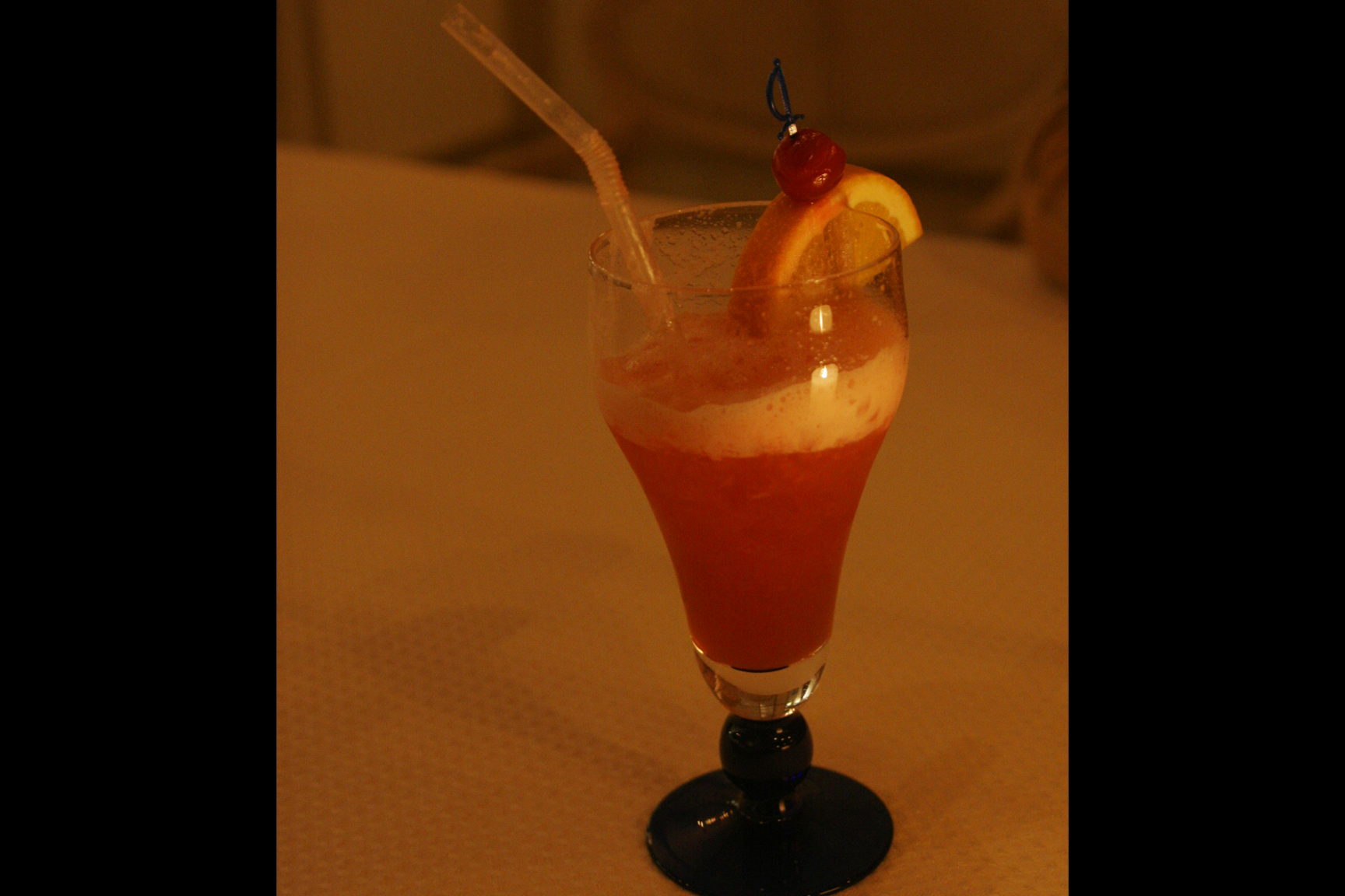 a drink sitting on a table topped with fruits and drinks