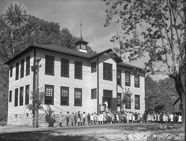 a black and white po of a house that has many people standing in front