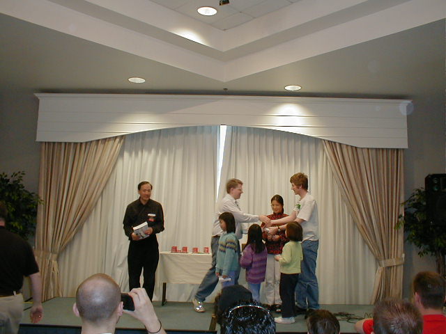 several people standing together as they hold wii remotes