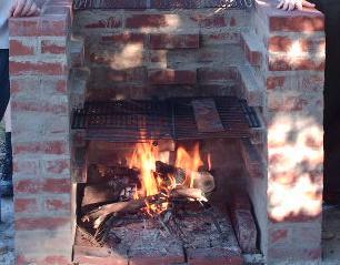 a person holding their hand near a brick oven