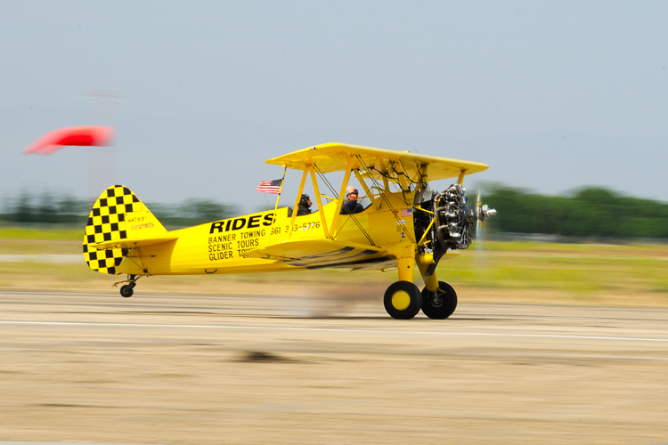 a small yellow plane on a runway