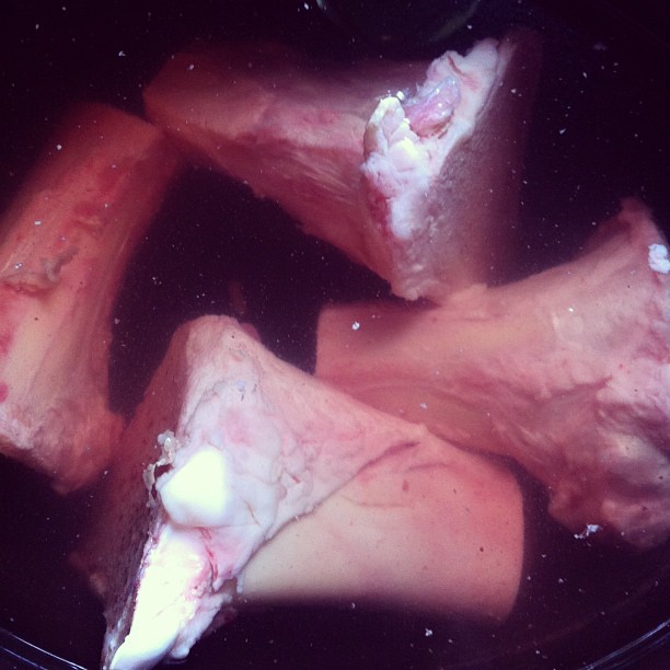 several pieces of meat being put into a frying pan