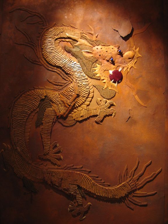 an intricate dragon carved onto the side of a wall