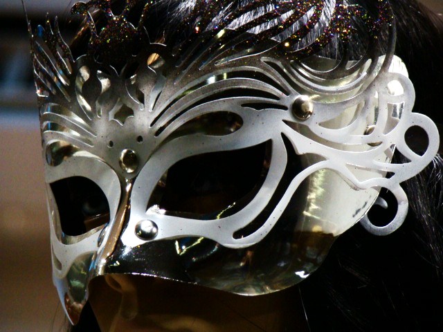 a woman in white mask and feathers on her face