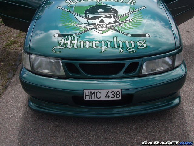 a green truck with a skull on the hood and two baseball bats