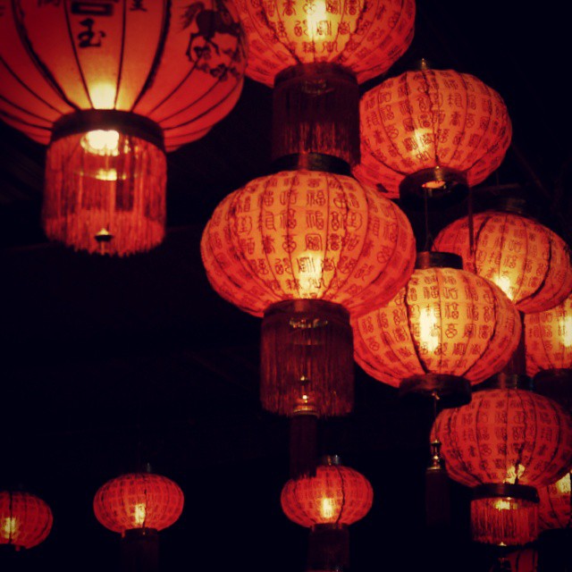 many red lanterns with chinese writing and lights