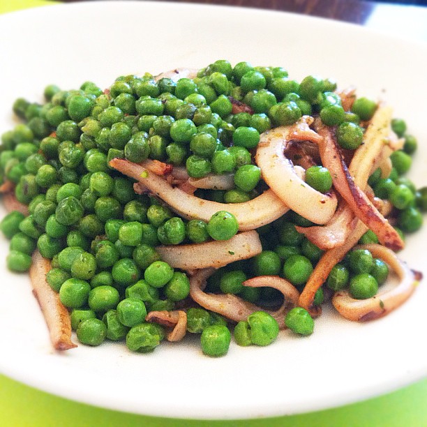 a plate that has peas on it, with onions