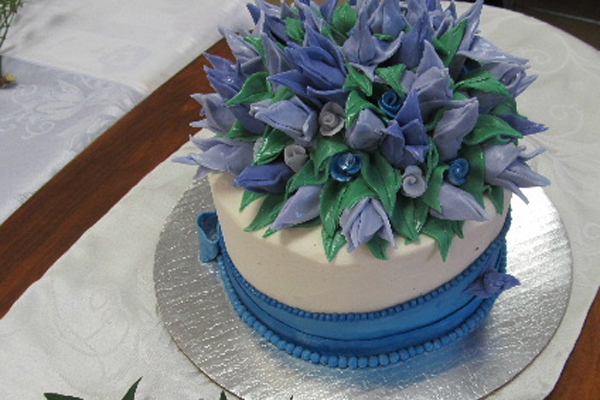 a small blue and white cake with flowers on it
