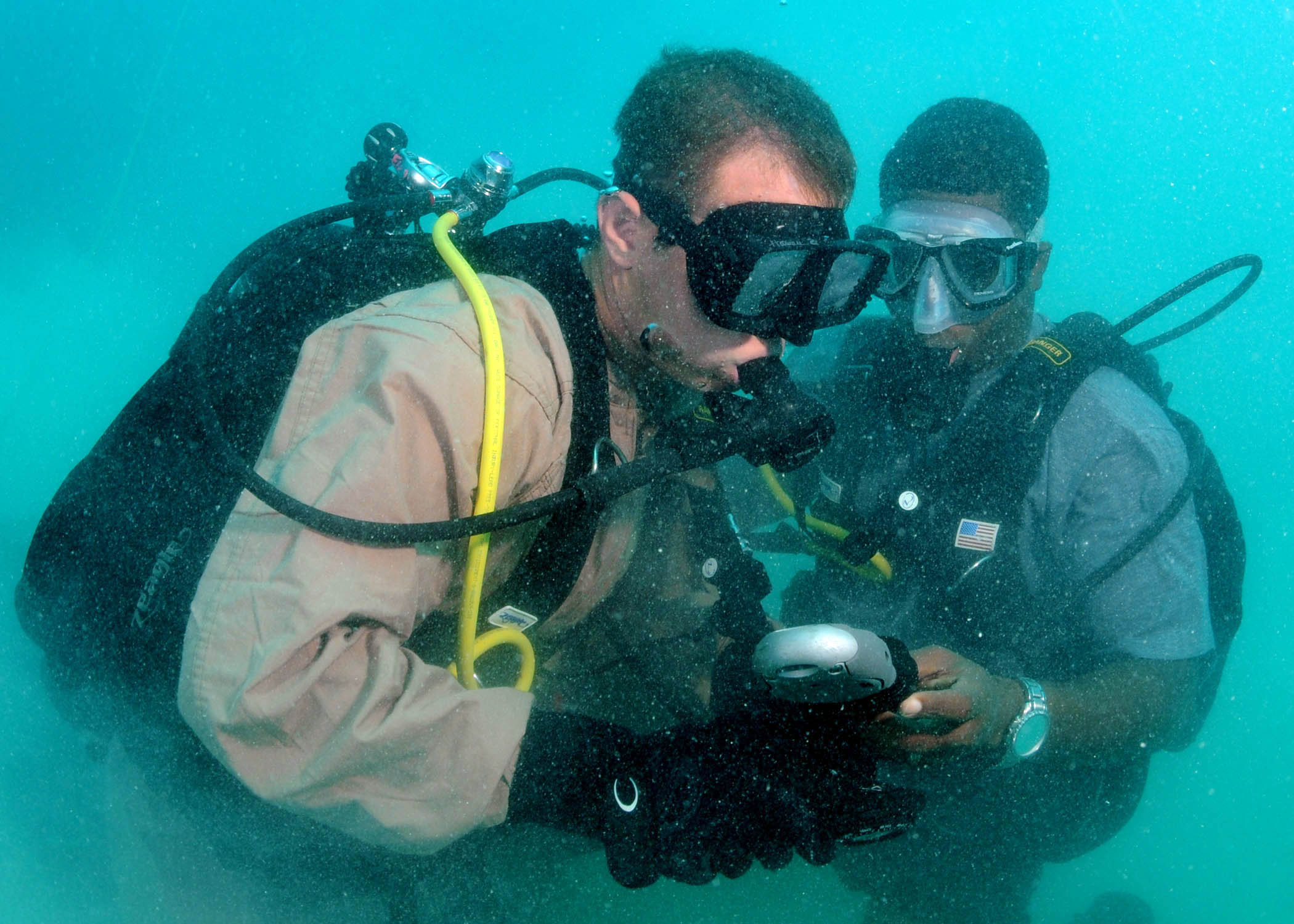 two people under water with equipment and scuba gear