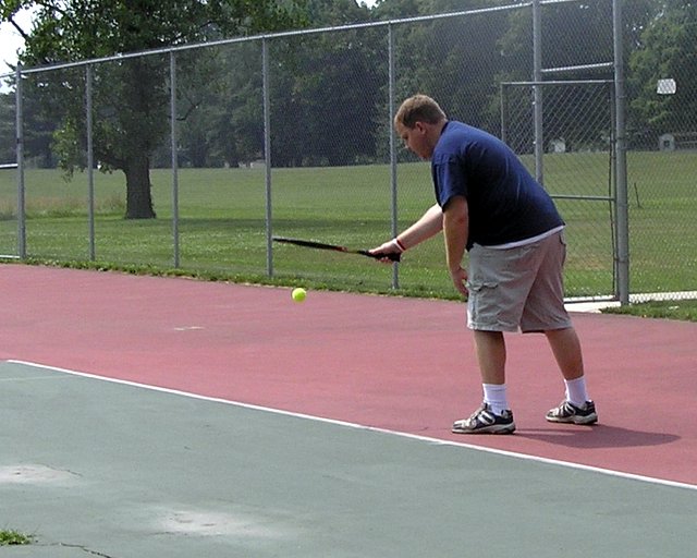 the man is trying to hit the tennis ball